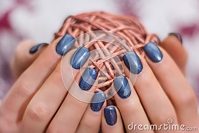 Female with navy blue nails polish holding decorative hank Stock Photo