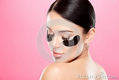 Young girl with nude make up and naked shoulders at studio background,black eye patches on face, beauty photo concept Stock Photo
