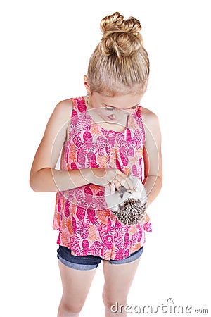 A young girl petting the stomach of her pet hedgehog Stock Photo