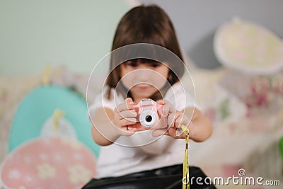 Young girl photographer make photo of her toy camera. Cute little girl play at home Stock Photo