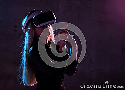 Young girl play virtual reality game wear vr glasses and explore alternative reality. woman in cyber space and virtual gaming Stock Photo