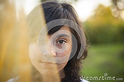 Young girl portrait half face hidden behind a veil. Stock Photo