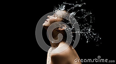 Young girl portrait and splash water in her face. beautiful female model on black background. Stock Photo