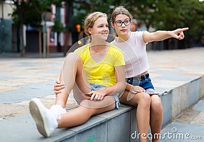 Girl prompts the girlfiend, pointing with his hand at something Stock Photo