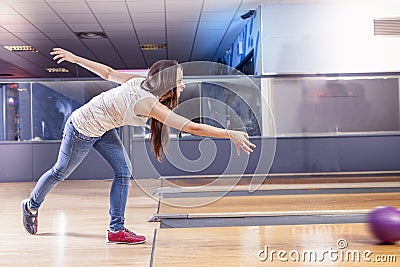 Young girl pulls the ball on the bowling alley Stock Photo