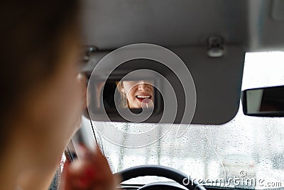 A young girl puts make-up in the car. Stock Photo