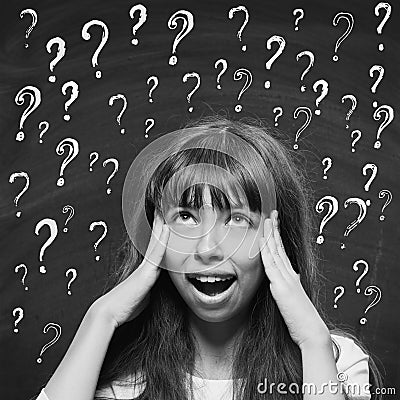 Young girl with questioning expression and question marks above Stock Photo