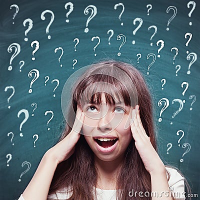 Young girl with questioning expression and question marks Stock Photo
