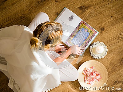 Young girl reading the bhagavad gita in the light of the setting suns Stock Photo