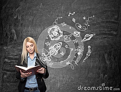 young girl reading blackboard with space objects at the background Stock Photo