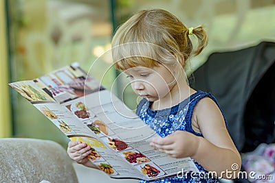 Young girl reading menu Stock Photo