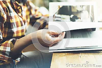 Young girl reads book during breakfast and coffee, female hands close up flipping through magazine pages in home relax atmosphere Stock Photo