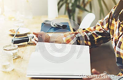 Young girl reads book during breakfast and coffee, female hands close up flipping through magazine pages in home relax atmosphere Stock Photo