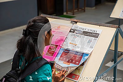 A young girl reads the newspaper in the college Editorial Stock Photo