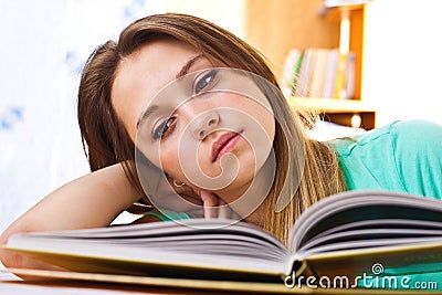 The young girl reads the textbook Stock Photo