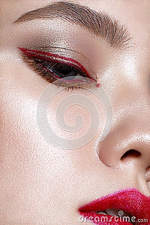 Young girl with red lips and red arrows in front of eyes. Beautiful model with makeup nude and shining skin. Photo taken in the st Stock Photo