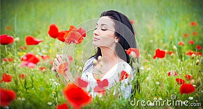 Young girl relaxing in green poppies field. Portrait of beautiful brunette woman posing in a field full of poppies Stock Photo