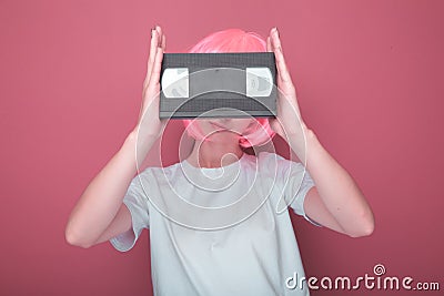 Young girl 90s and VHS cassette on pink Stock Photo