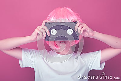 Young girl 90s and VHS cassette on pink Stock Photo