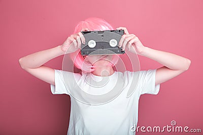 Young girl 90s and VHS cassette on pink Stock Photo