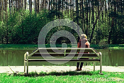 Young girl sad and sit on a wooden bench in the Park, she was disappointed by the sweet love. dreams of the future. Editorial Stock Photo