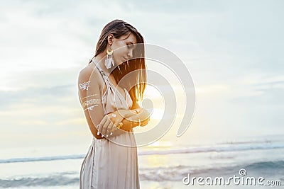 Young girl with silver tattoo and boho jewelry on sunset Stock Photo