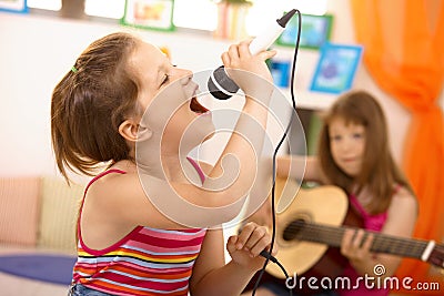 Young girl singing with microphone at home Stock Photo