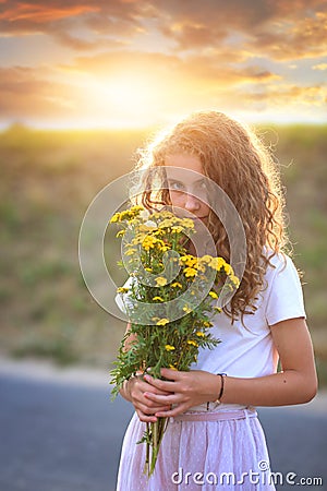 Young girl smells wildflowers Stock Photo