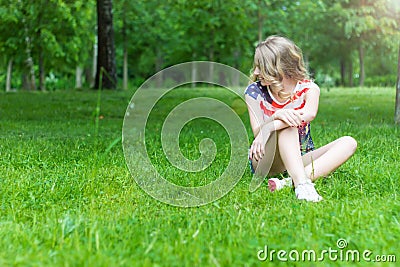 Young girl is smiling and happy sitting on the grass in summer Sunny day Stock Photo