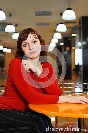 Young girl sorrowful sitting in empty cafe Stock Photo