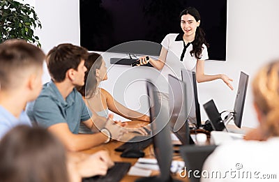 Young girl speaker stands in front of students and talks about use of artificial intelligence Stock Photo