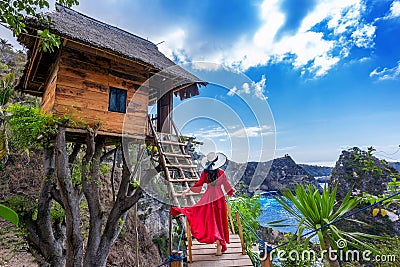 Young girl on steps of house on tree at Atuh beach in Nusa Penida island, Bali in Indonesia. Stock Photo