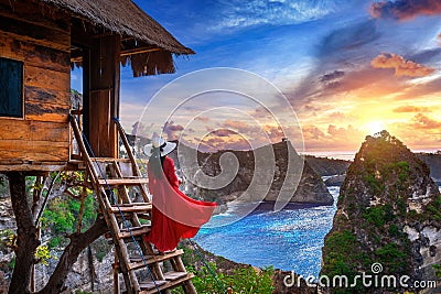 Young girl on steps of house on tree at sunrise in Nusa Penida island, Bali in Indonesia Stock Photo