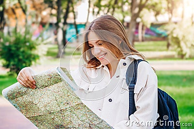 A young girl student walks around the city with a map and looking for a way. Exchange students concept Stock Photo