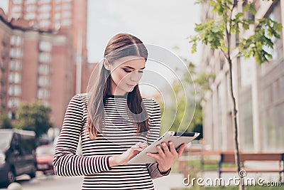 Young girl is studying in the spring park outside, browsing on h Stock Photo