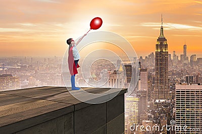 The young girl in superhero costume overlooking the city Stock Photo