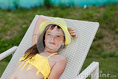 Young girl in a swimsuit on a shelf by the pool Stock Photo