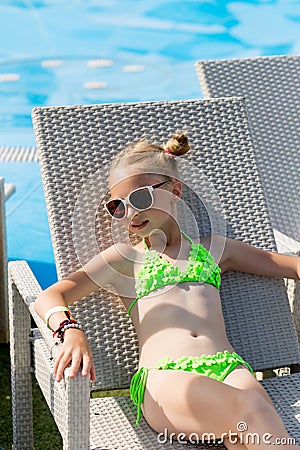 Young girl in a swimsuit on a shelf by the pool Stock Photo