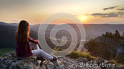 Young girl tourist looks at sunset over Zakopane from the top of the mountain, Poland, High Tatras Stock Photo