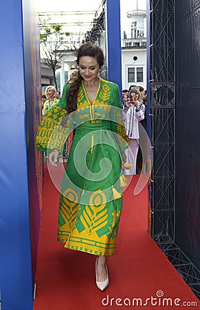 Young girl in Ukrainian national embroidered dress posing in front of a crowd of people. Celebration of Embroidered Editorial Stock Photo