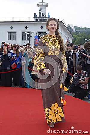 Young girl in Ukrainian national embroidered dress posing in front of a crowd of people. Celebration of Embroidered Editorial Stock Photo