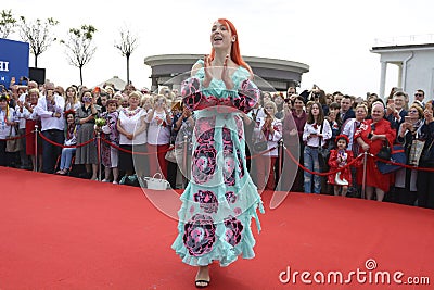 Young girl in Ukrainian national embroidered dress posing in front of a crowd of people. Celebration of Embroidered Editorial Stock Photo