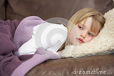 Young Girl Unwell Lying On Sofa Stock Photo