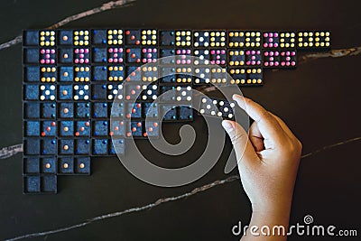 Young girl using her hand to check the total number of dominoes before playing. People search and find missing dominoes. Neatly Stock Photo