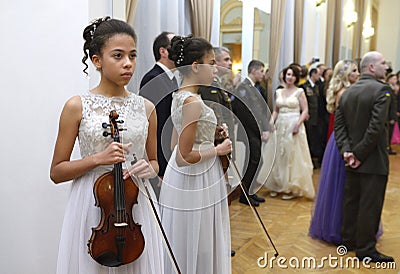 Young girl violinist standing with a violin in hand waiting for her performance during dance ball, celebration of Editorial Stock Photo