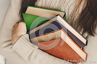 Young girl holds three books in hands Stock Photo