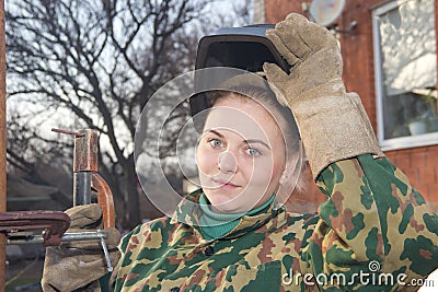 A young girl welder in working clothes Stock Photo