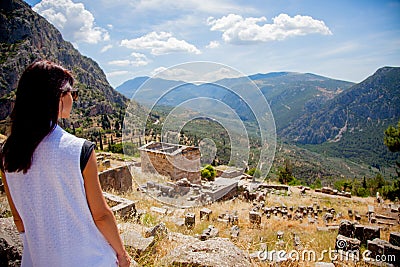 Young girl in white clothes standing on rock in Greece Stock Photo