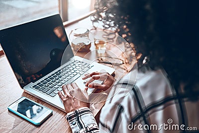 A young girl works in a cafe. Back view. On the monitor screen is a miniature of the starry sky. Creation of the designer Stock Photo