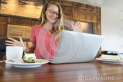The young girl works at the computer and cake, food at the computer, a bad habit eats. Stock Photo